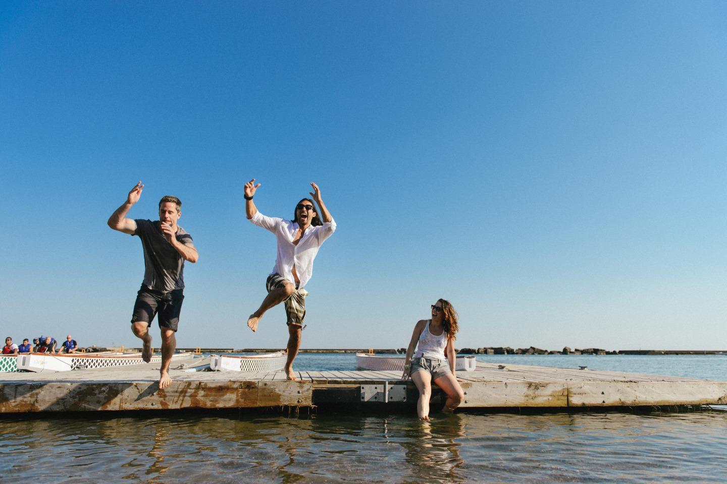 men jumping off a dock